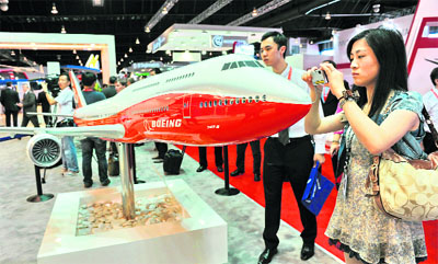 A visitor takes a picture of the Boeing 747-B plane at the ongoing Singapore Airshow on Tuesday. American multinational aerospace major Boeing and Indonesian carrier Lion Air formally signed a US $22.4 billion deal for 230 aircraft, the single largest contract in commercial aviation history. 
