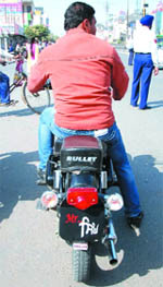 A man rides a motor-cycle with an unusual number plate that reads Mr Singh, in Bathinda on Tuesday. 