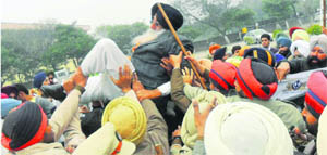 Police personnel take away SAD (A) president Simranjit Singh Mann after he held a protest outside the gate of  Shri Guru Granth Sahib World University in Fatehgarh Sahib on Tuesday. Mann and his supporters were protesting against Dr Jasbir Singh Ahluwalia rejoining the university as VC. 