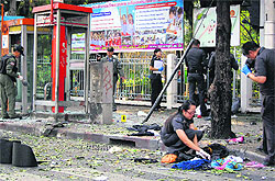 Police and forensic experts examine the blast site in Bangkok on Tuesday