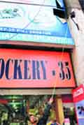 An employee of the shop shows the broken window from where the accused fled in Sector 35, Chandigarh,