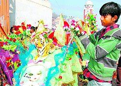 Sharad, a young Kanwariya, decorating a kanwar at Malviya Ghat with red roses in Haridwar on Thursday
