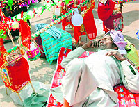 A Kanwariya rests along side his beautifully decorated kanwar in Haridwar on Thursday