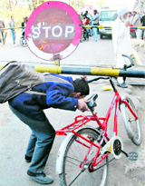 A schoolboy tries to cross a barrier at a railway crossing in Patiala.