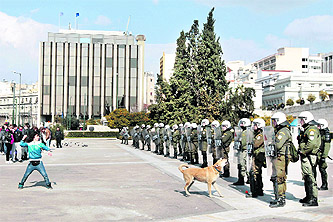 A youth throws a stone at policemen guarding the parliament during an anti-austerity rally in Syntagma Square in central Athens on Friday. Greece appears to be closing in on a new international rescue package despite unresolved doubts among eurozone partners about how fast it would manage to bring its debt down.