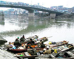 Fishermen take a break in their shikaras on the Jhelum in Srinagar on Thursday
