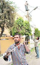 Power corporation staff replace cables in Patiala on Saturday. Due to the ongoing maintenance work, long power cuts are being imposed in the city. Students preparing for their final exams are the worst hit