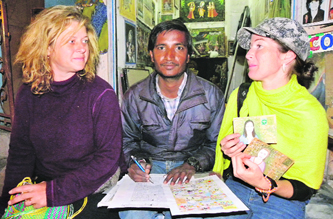 Yug Prasad with foreign travellers; and (right) an original photo and Prasads portrait of a tourist couple.