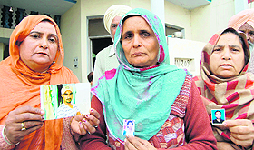 Family members show pictures of youths lodged in an Abu Dhabi jail. 