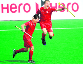 Artur Mikula of Poland (R) celebrates a goal during their match against Canada in New Delhi on Sunday. Poland won the match 3-2.  AFP
