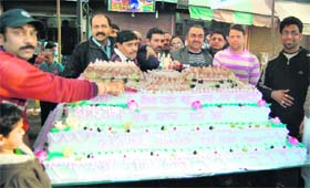 Members of Amarnath Sewa Mandal cut a cake to celebrate the festival of Shivratri in Amritsar on Monday. 