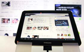 Samsungs Galaxy Tab is displayed in front of a flat screen TV at an exhibition hall in Seoul on Monday