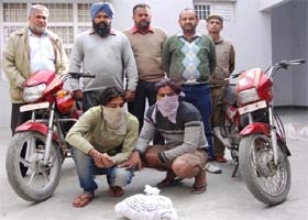 Two members (with covered faces) of a gang of robbers, who were arrested by the police, at the Canal Colony police station in Bathinda on Monday