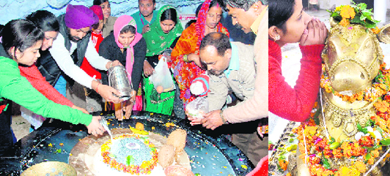 Devotees offer milk and Ganga jal on a Shivalingam at the Tapkeshwar Mahadev temple in Dehradun on Monday; and (right) a girl whispers something into the ears of Nandi bull at a Lord Shiva temple in Haridwar. 
