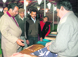 Dehradun Mayor Vinod Chamoli sees products after inaugurating a handloom expo in Dehradun