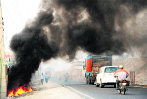 Thick smoke emanates from the burning garbage near the Namaste Chowk on the National Highway-1 in Karnal. 