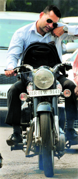 A motorcyclist uses his mobile phone while driving in Ludhiana.