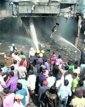 Fire fighters douse a fire that broke out at a petrol pump in Surat on Monday.