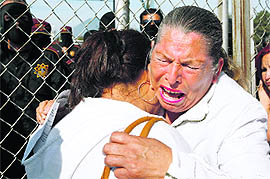 Relatives of inmates cry while waiting outside Apodaca prison on Sunday. 