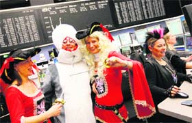 Bourse traders dressed in costumes pose for a picture during early morning trading at the Frankfurt Stock Exchange, the world's 12th largest exchange by market capitalization, on Tuesday