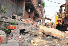 The enforcement staff remove illegal structures in Sector 20 in Chandigarh on Wednesday. 