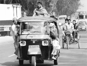An overloaded auto-rickshaw on the Zirakpur-Patiala highway. Tribune Photo: Nitin Mittal