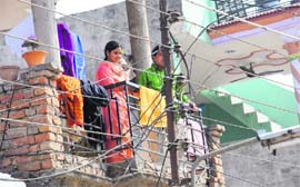 Residents stand near electricity wires at Kishangarh in Chandigarh. 
