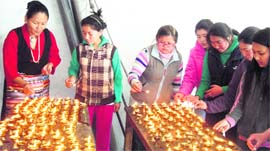 Head of the Tibetan Women Association Kalsang Dolma (extreme left) lights butter lamps along with students to mark the Losar celebrations in Mussoorie on Wednesday
