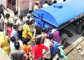 Residents collect water from a tanker in Faridabad. 