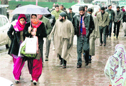 People walk in the rain in Srinagar.