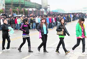 Job seekers cross a road as they line up outside a Foxconn recruitment centre in Shenzhen, Guangdong province, on Wednesday