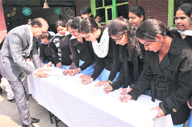 Kabir Khan, consultant with the Punjab ombudsmans office in Pakistan, takes part in a signature campaign at the Dev Samaj College of Education in Sector 36 of Chandigarh on Thursday. 