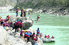 Rafting enthusiasts participate in adventure activities in the Ganga river in Rishikesh. 
