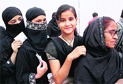 Voters stand in a queue to cast their votes at a polling station during the fifth phase of Uttar Pradesh Assembly polls in Kanpur on Thursday