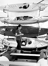 A girl stands near kayaks on display at the International Boat Show in Mumbai on Thursday