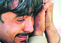 A man reacts after his brother was killed in a car blast on the outskirts of Peshawar on Thursday