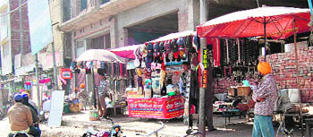 Shopkeepers put up stalls on the footpath near Shaheed Baba Deep Singh Gurdwara in Amritsar. 
