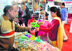 Girls buy decorative items at a stall during a trade fair at Kala Kendra in Jammu.