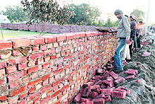 The wall of the girls hostel of DAV College being reconstructed in Jalandhar on Friday. 