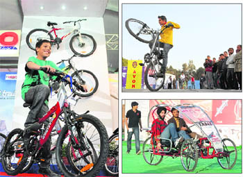 A boy enjoys a ride on a bicycle during the expo in Ludhiana; A youth performs a stunt during the event; Students of Guru Nanak Dev Engineering College display their design at the expo. 