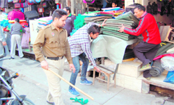 A team of the Municipal Corporation confiscates goods of shopkeepers that were put up on the footpaths in Amritsar