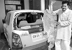 A man shows the shattered window pane of his car at Swasthik Vihar, Zirakpur, on Saturday