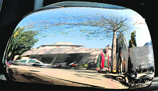 The world as it appears in the rear window pane of a car.