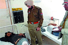 A policeman with one of the injured in the attack that took place at Mal Godam road on Sunday