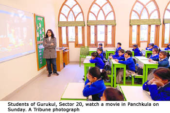 Students of Gurukul, Sector 20, watch a movie in Panchkula on Sunday. A Tribune photograph