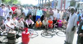 People hold a protest against the sale of LPG cylinders on the black market in Haridwar on Sunday.