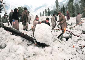 Villagers search for their belongings after their huts were buried under an avalanche at Ramwari, 70 km from Srinagar, on February 23