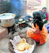 Cooks prepare mid-day meals in the open at a school in Patiala. 