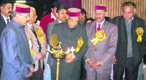 Chief Minister PK Dhumal lights the lamp at the Sobha Singh Auditorium of the medical college in Tanda on Monday.
