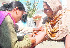 A health worker takes a blood sample from a resident